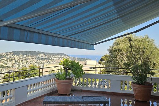 Terrasse avec plantes, vue Nice et collines, ombragée.